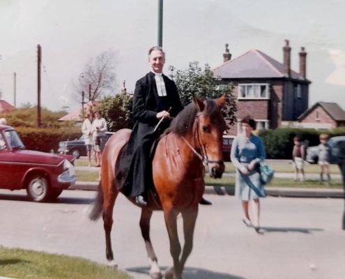 Rev Frank Rothwell on horseback celebrating Wesley Day mid 60s This is a picture of the Methodist Minister dressed as John Wesley, commemorating his bicentenary, on my mum's horse, Tasha who he borrowed for the occasion. She was such a good mare, steady as a rock. That is my mum hovering close at hand in blue. The pictures is taken just outside our house on the corner of Greasby Road and Circular Drive. Sometime mid sixties. With kind permission and thanks to Elspeth Carr
